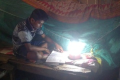 Zerstörung-und-Hilfe-Junge-mit-Solar-Lampe-unter-Moskitonetz